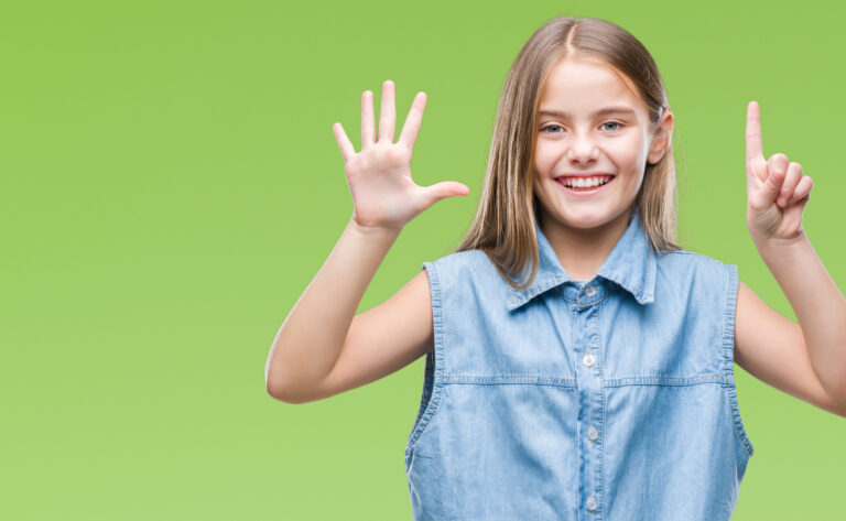 Girl with fingers showing number six while smiling confident and happy.